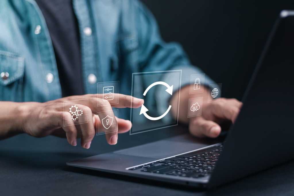 Person at laptop keyboard shown updating software.